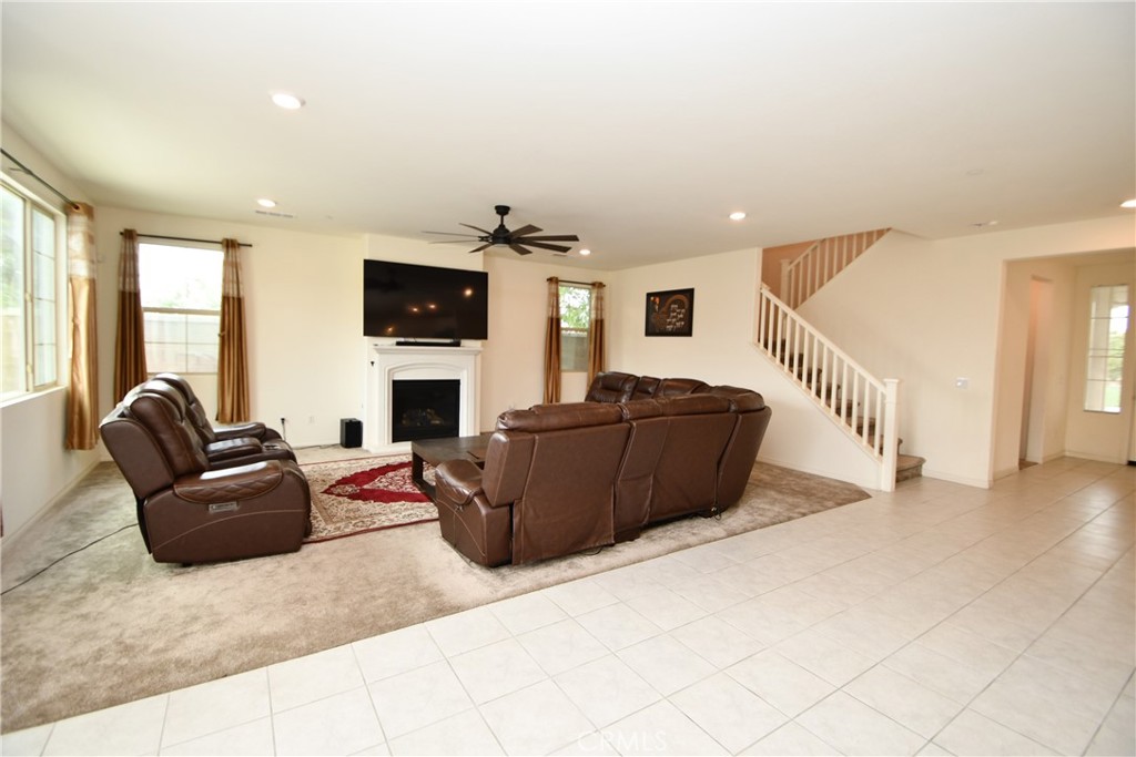 5367 Heitz Way Fontana, CA 92336 - Photo 8 of 50 a living room with furniture a flat screen tv and a fireplace