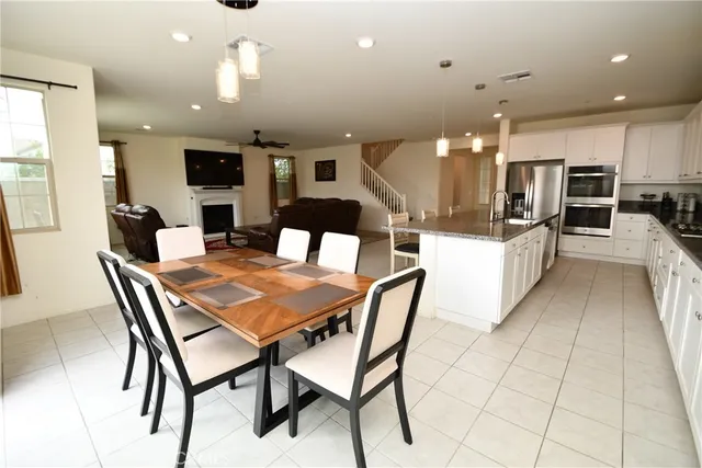 a dining area with a table chairs and a kitchen view