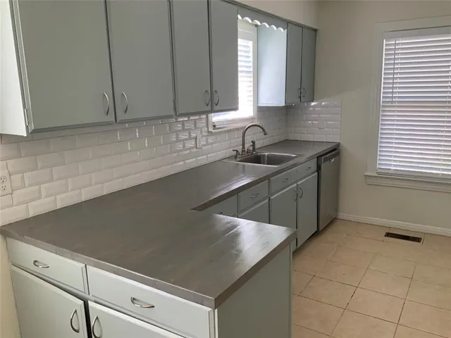 a kitchen with a sink cabinets and window