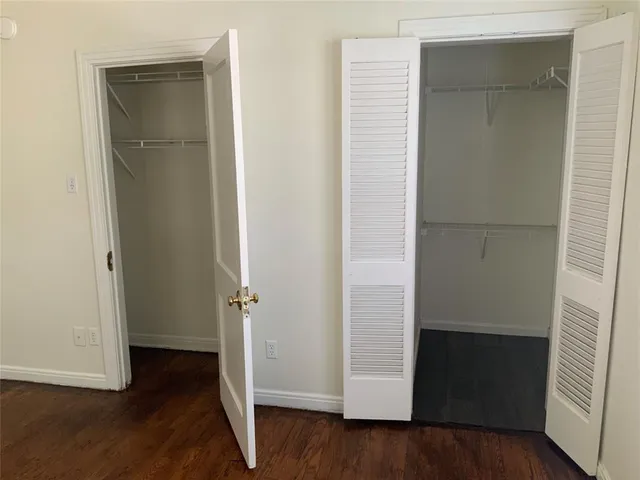 an empty room with wooden floor and closet