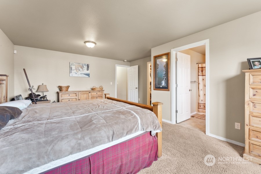9422 Gastaeson Lane Southwest Rochester, WA 98579 - Photo 27 of 35 a spacious bedroom with a bed and glass door