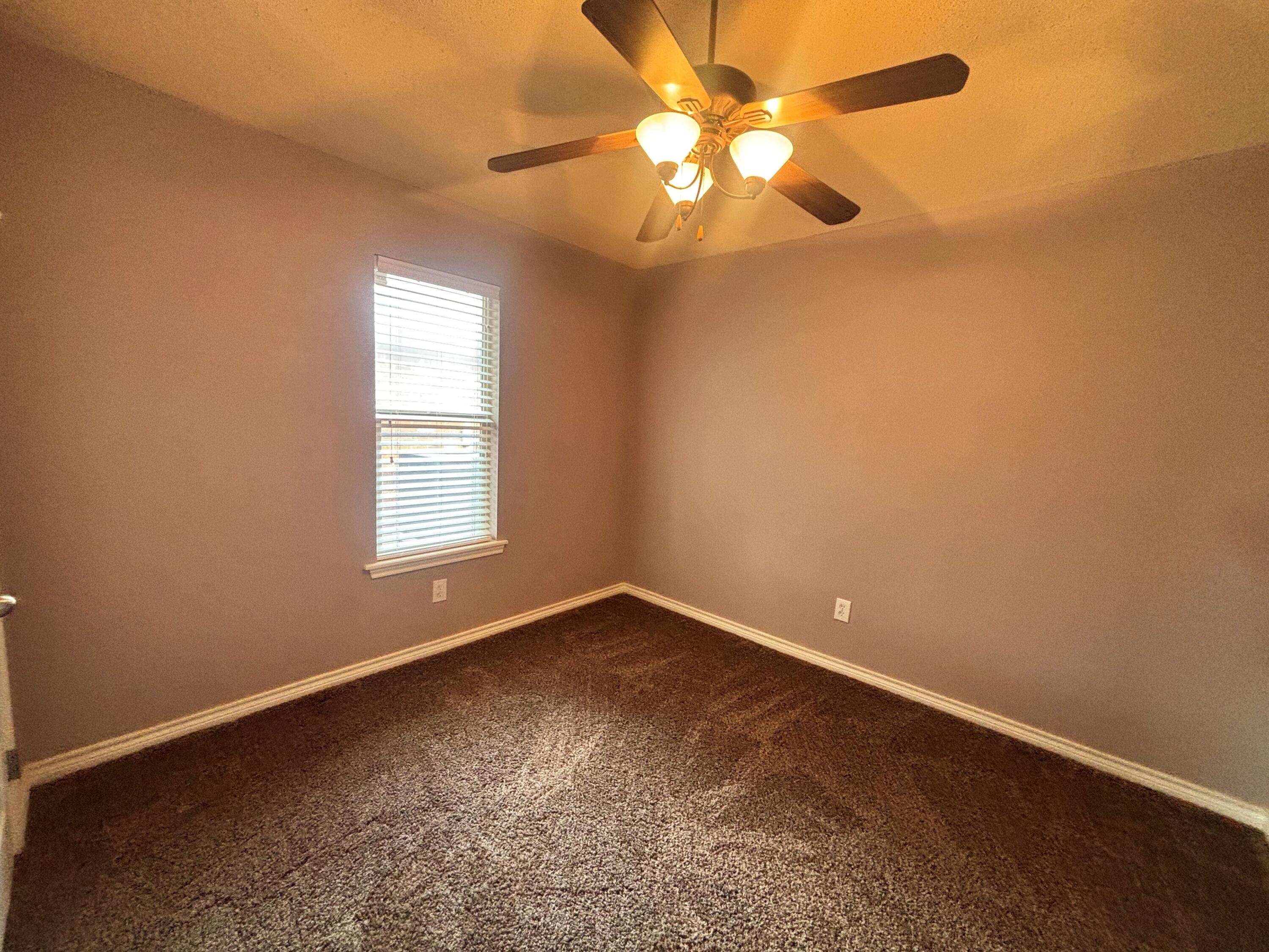 3713 106th Street Lubbock, TX 79423 - Photo 15 of 22 an empty room with windows and fan