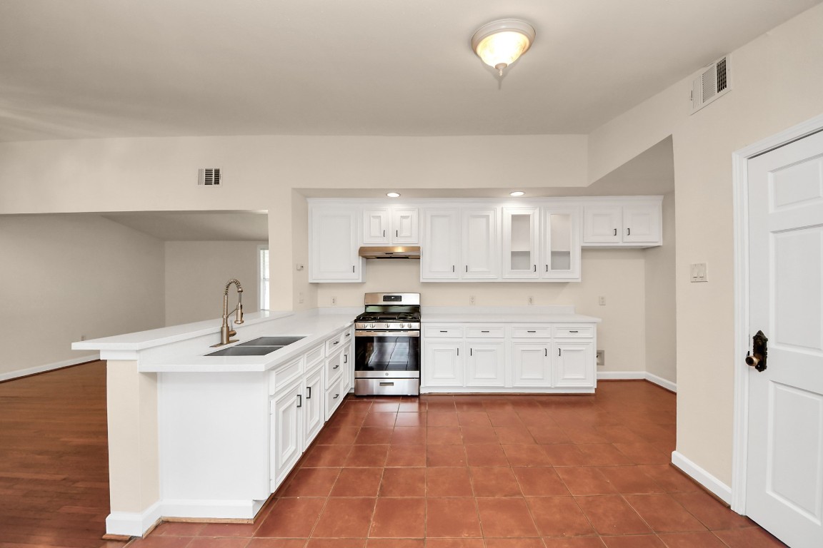 6701 Neff Street Houston, TX 77074 - Photo 13 of 44 Updated kitchen with white cabinetry, modern countertops, stainless steel appliances, and breakfast bar.