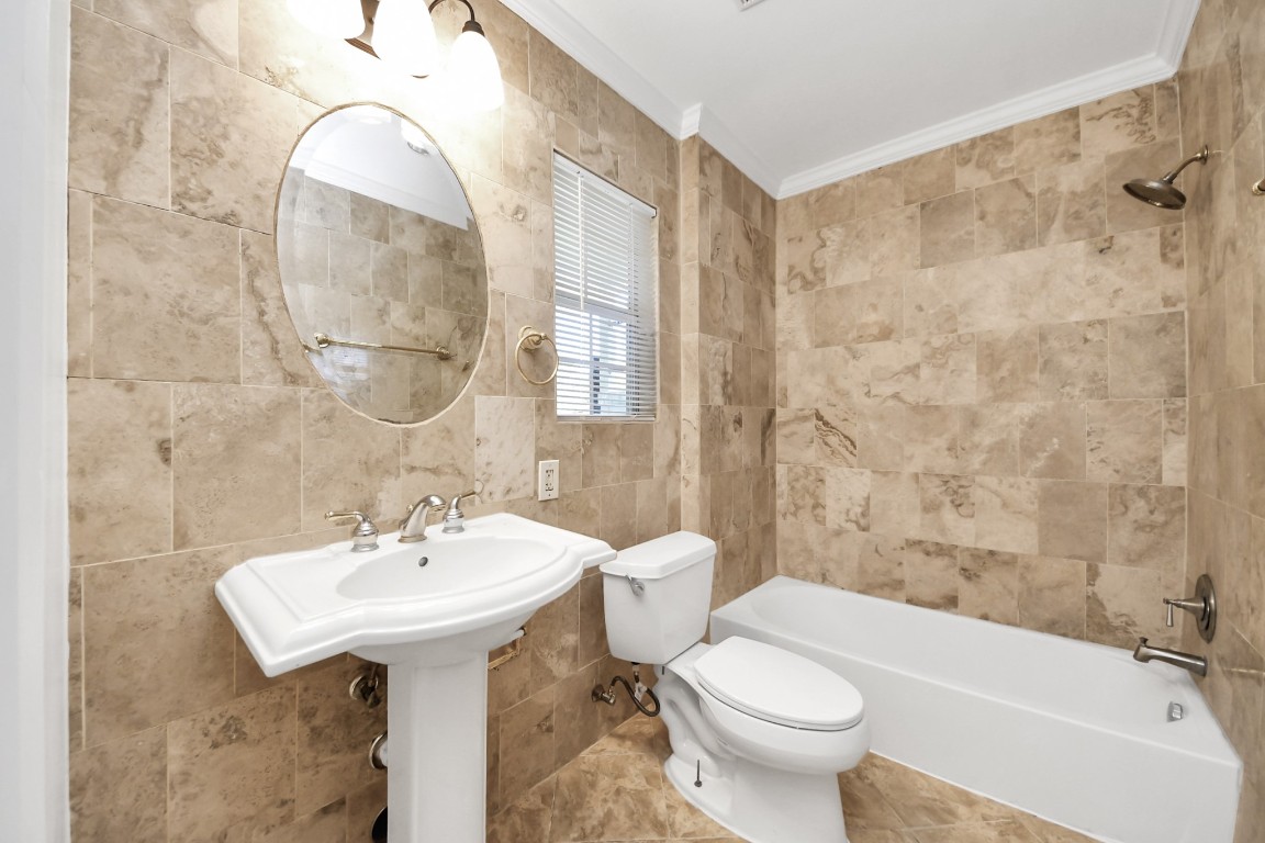 6701 Neff Street Houston, TX 77074 - Photo 23 of 44 Bathroom vanity area with pedestal sink, updated lighting, and tile finishes.