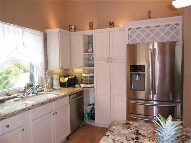 100 Cape Pointe Circle Jupiter, FL 33477 - Photo 6 of 25 a kitchen with stainless steel appliances granite countertop a refrigerator and a sink