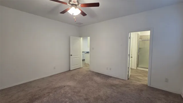 an empty room with closet and a chandelier fan