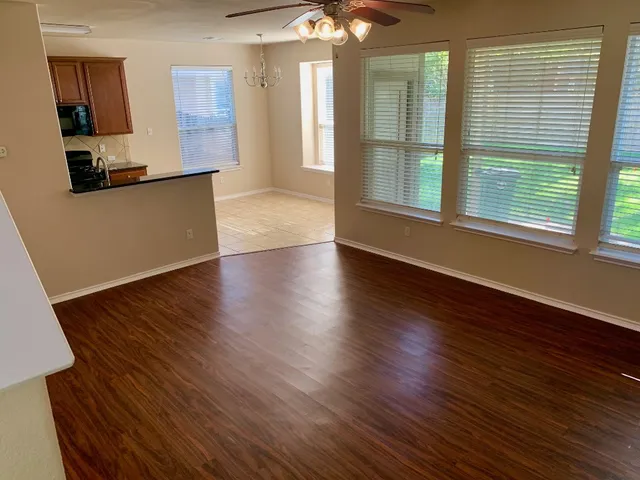 a view of a kitchen with furniture and wooden floor