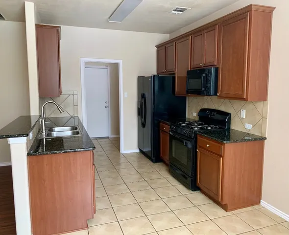 a kitchen with stainless steel appliances granite countertop a refrigerator stove and microwave