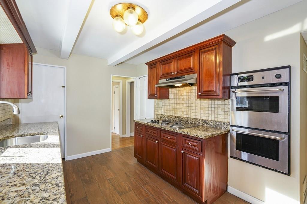 1309 Washington Street Canton, MA 02021 - Photo 7 of 35 a kitchen with stainless steel appliances granite countertop a stove and a microwave