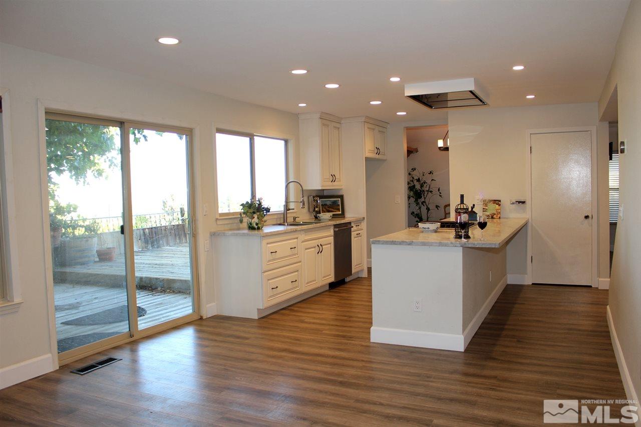 3824 Bexley Square Reno, NV 89503 - Photo 6 of 25 a kitchen with kitchen island white cabinets and wooden floor