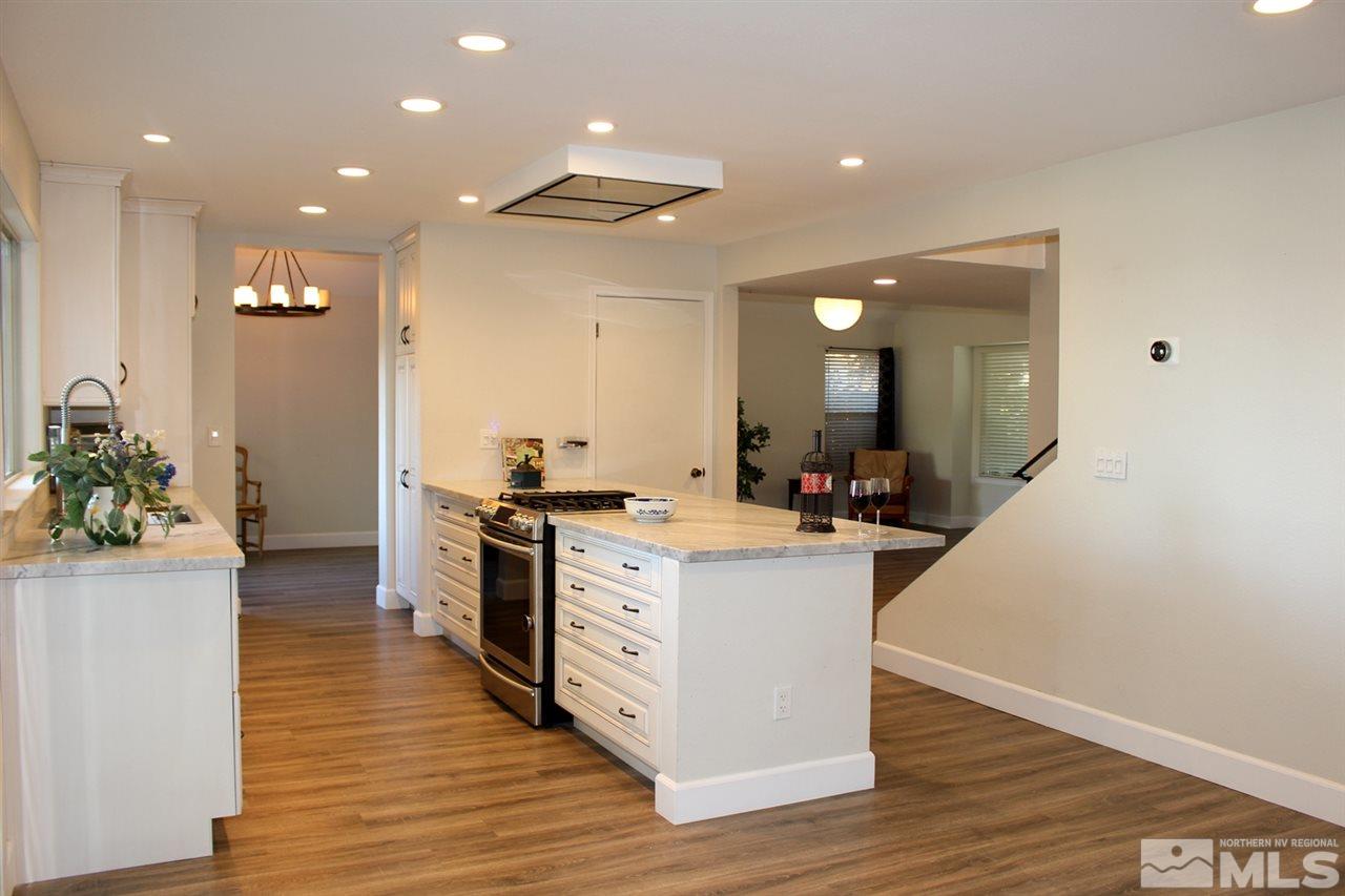 3824 Bexley Square Reno, NV 89503 - Photo 7 of 25 a large white kitchen with wooden floor and stainless steel appliances