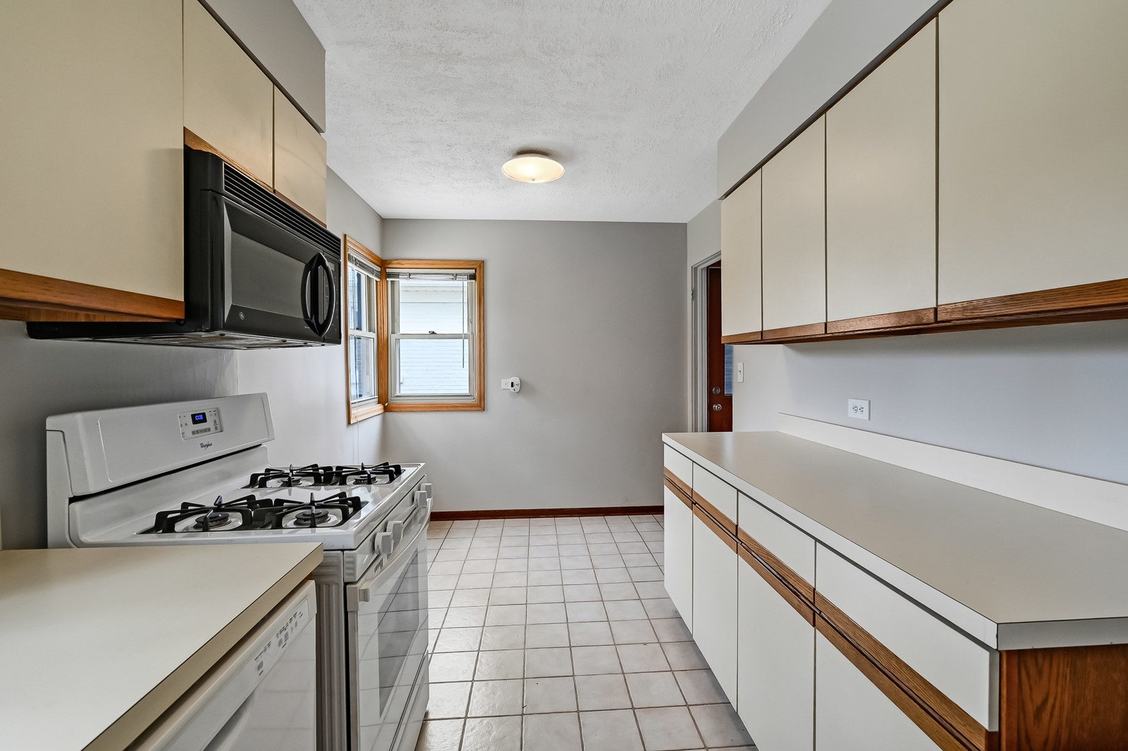 5208 Wolf Road Western Springs, IL 60558 - Photo 9 of 18 a kitchen with a sink a stove cabinets and a window
