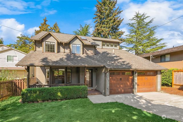 a front view of a house with a garden and yard