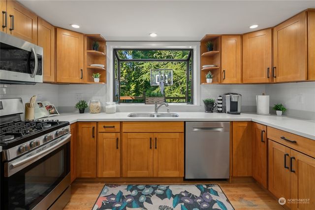 a kitchen with stainless steel appliances a sink stove and cabinets