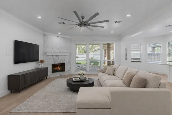 a living room with furniture a flat screen tv and a fireplace