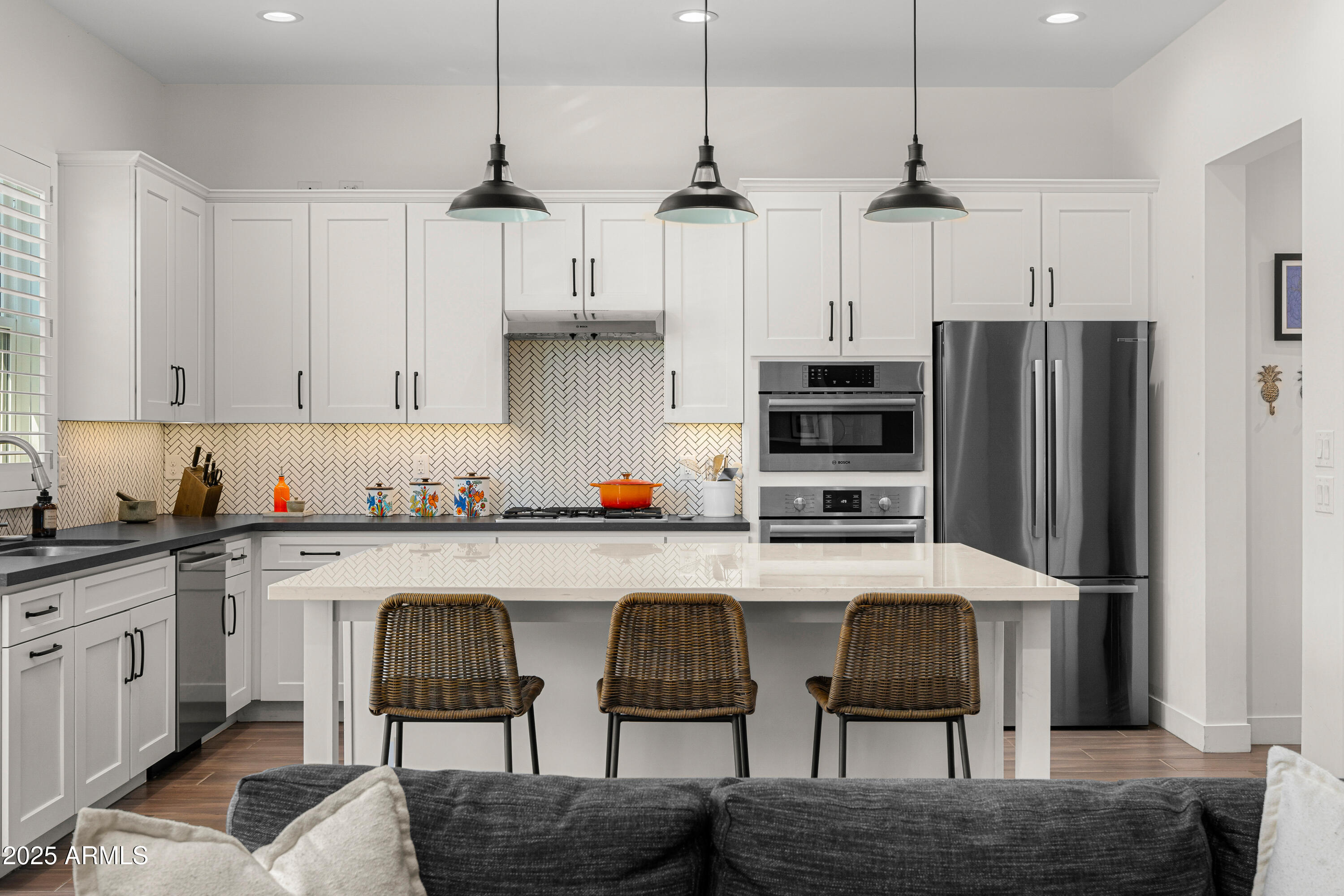 3200 North 39th Street, Unit 11 Phoenix, AZ 85018 - Photo 5 of 24 a kitchen with stainless steel appliances granite countertop a kitchen island hardwood floor and a view of living room