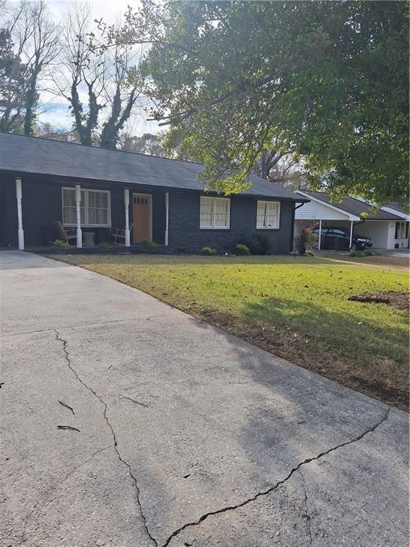 a front view of a house with a yard and trees
