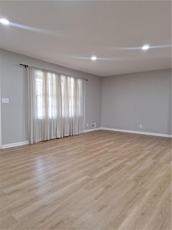 1605 Brockett Road Tucker, GA 30084 - Photo 11 of 12 a view of an empty room with wooden floor and a window