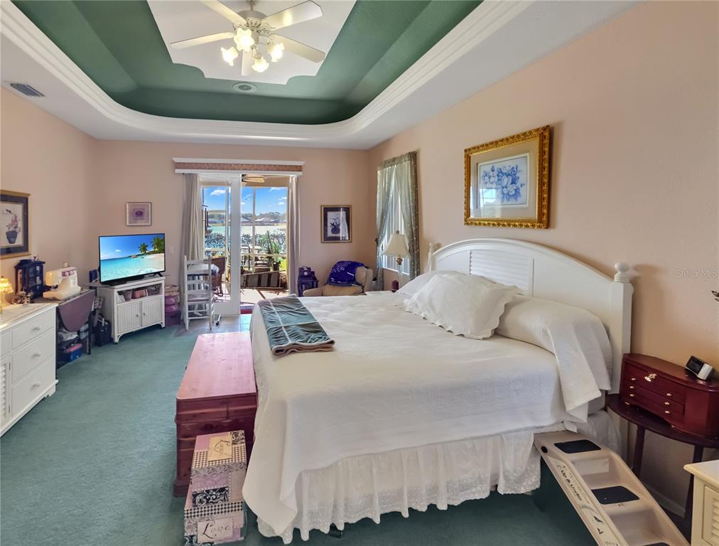 77 Hickory Loop Ocala, FL 34472 - Photo 16 of 50 a bedroom with a bed a chandelier and a dresser
