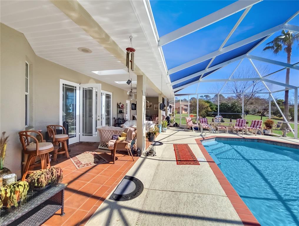 77 Hickory Loop Ocala, FL 34472 - Photo 41 of 50 a view of a patio with dining table and chairs under an umbrella