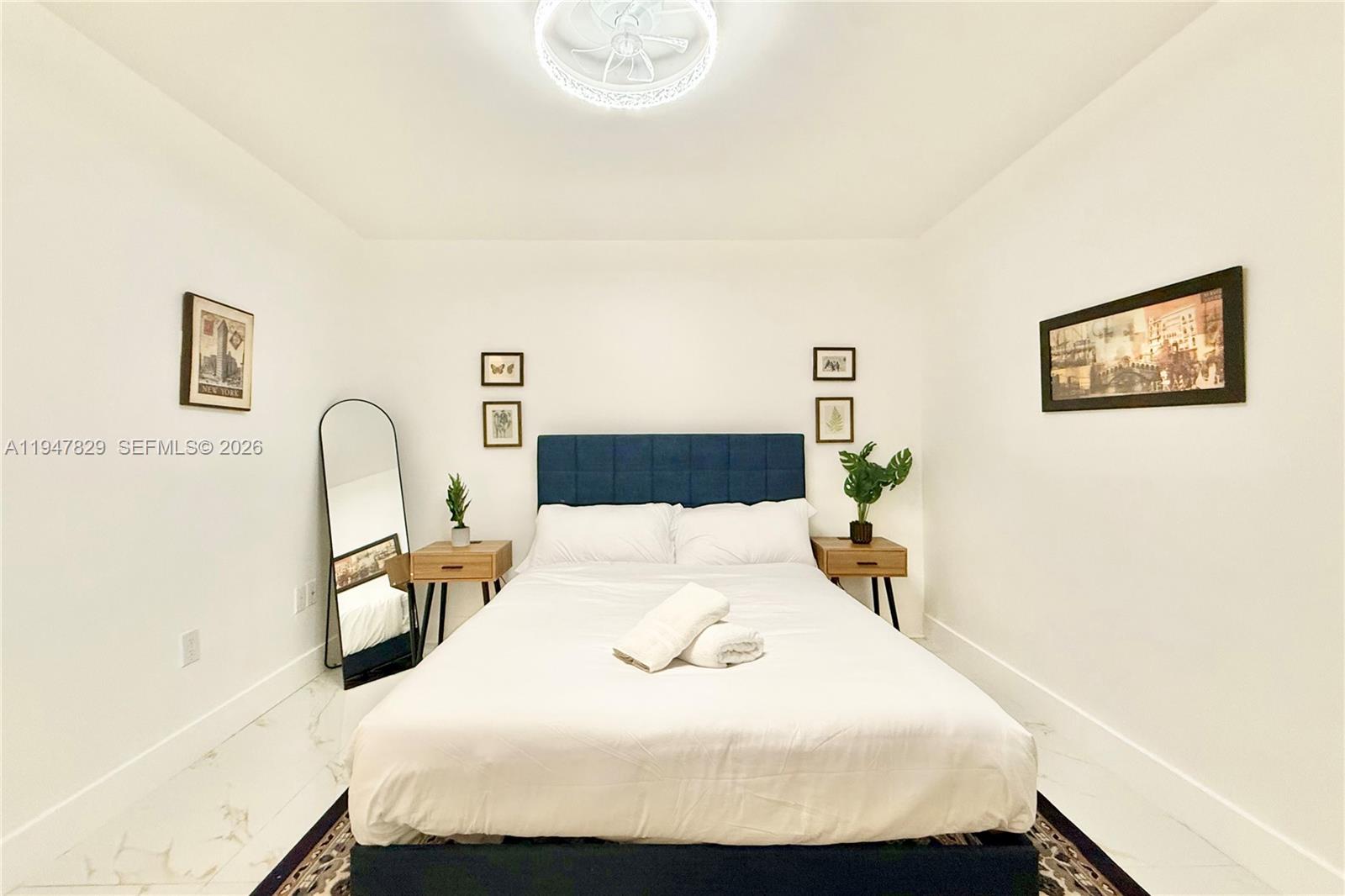 2216 R Northeast 18th Avenue, Unit RNT Wilton Manors, FL 33305 - Photo 13 of 16 a bedroom with a bed and a large mirror on a dresser