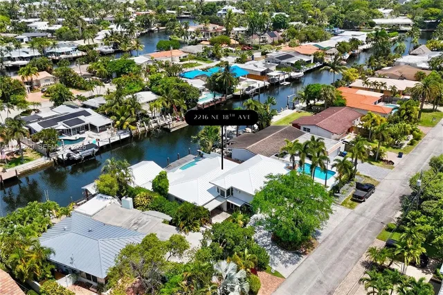 an aerial view of residential houses with outdoor space and lake view