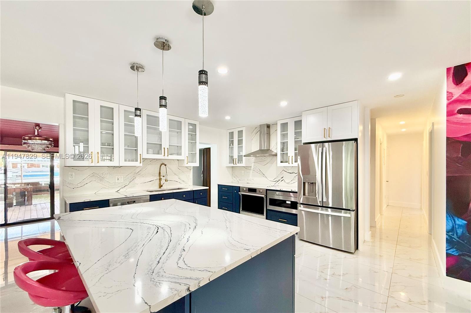 2216 R Northeast 18th Avenue, Unit RNT Wilton Manors, FL 33305 - Photo 4 of 16 a kitchen with stainless steel appliances kitchen island granite countertop a refrigerator and a sink