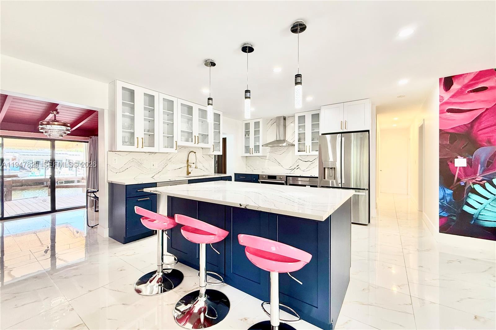2216 R Northeast 18th Avenue, Unit RNT Wilton Manors, FL 33305 - Photo 5 of 16 a kitchen with stainless steel appliances kitchen island a table chairs in it and wooden floors