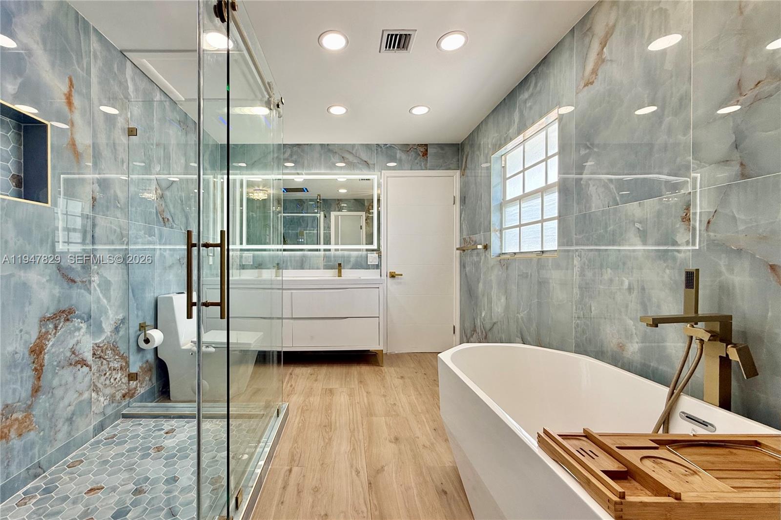 2216 R Northeast 18th Avenue, Unit RNT Wilton Manors, FL 33305 - Photo 8 of 16 a bathroom with a tub a sink and glass door