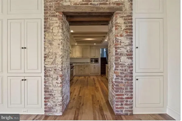 an empty room with wooden floor fireplace and windows