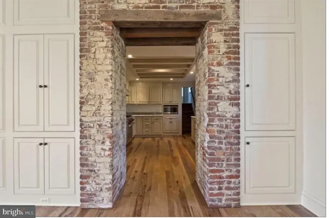an empty room with wooden floor fireplace and windows