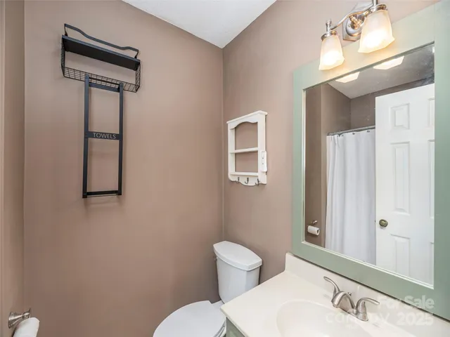 a bathroom with a toilet a sink and mirror