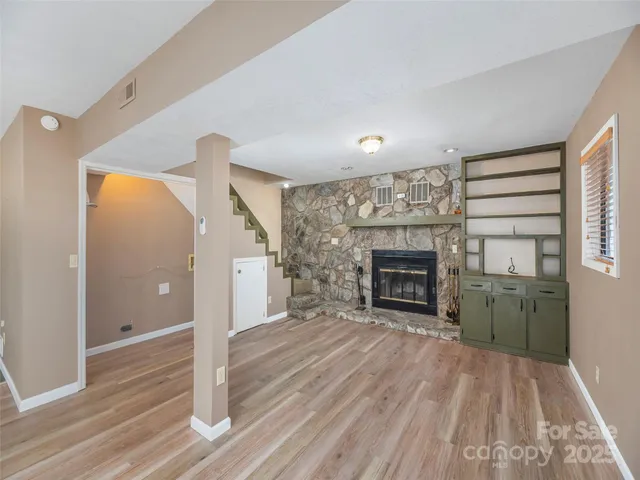 a view of a livingroom with a fireplace and window