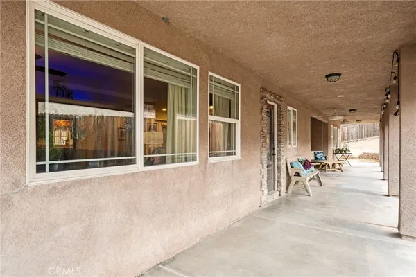 a view of a porch with a table and chairs and floor to ceiling window