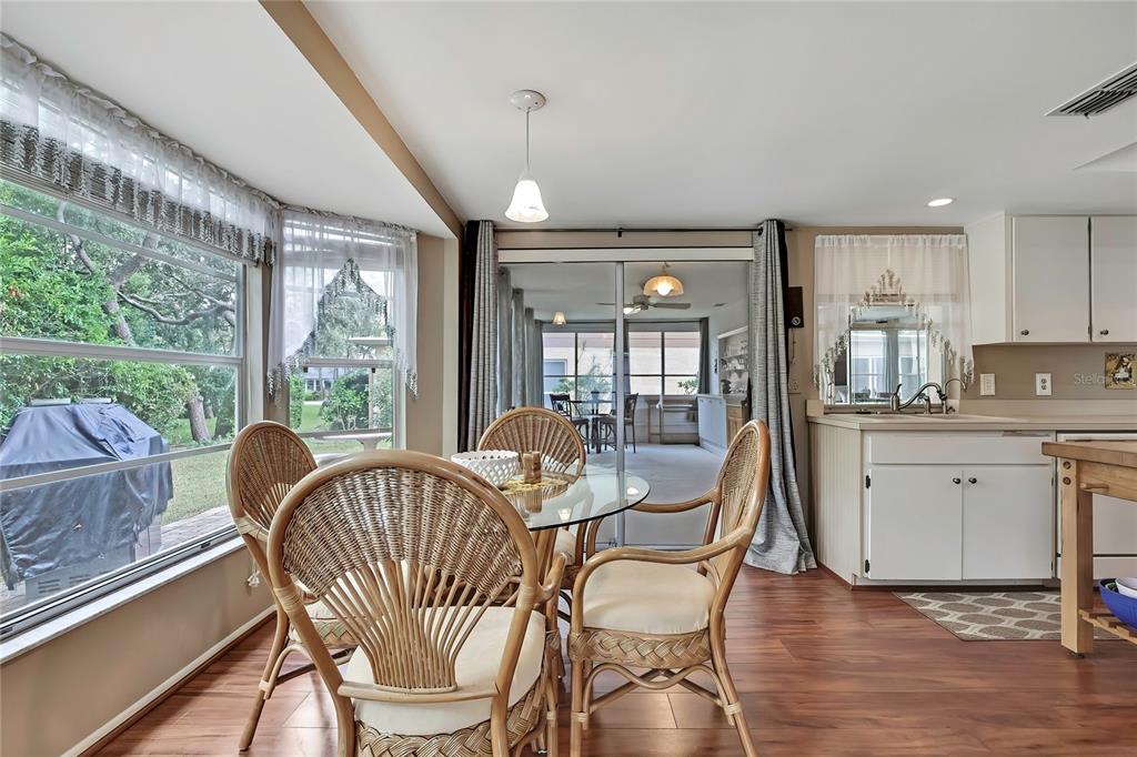6517 Ocean Pines Lane Spring Hill, FL 34606 - Photo 13 of 72 a dining room with furniture a chandelier and wooden floor