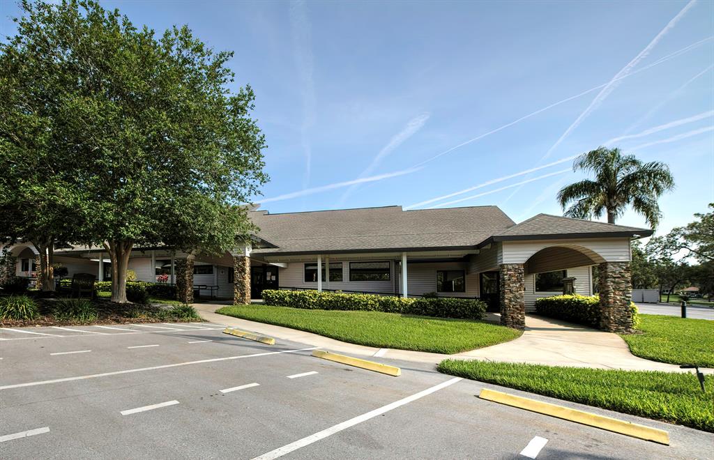 6517 Ocean Pines Lane Spring Hill, FL 34606 - Photo 51 of 72 a front view of a building with a garden and plants