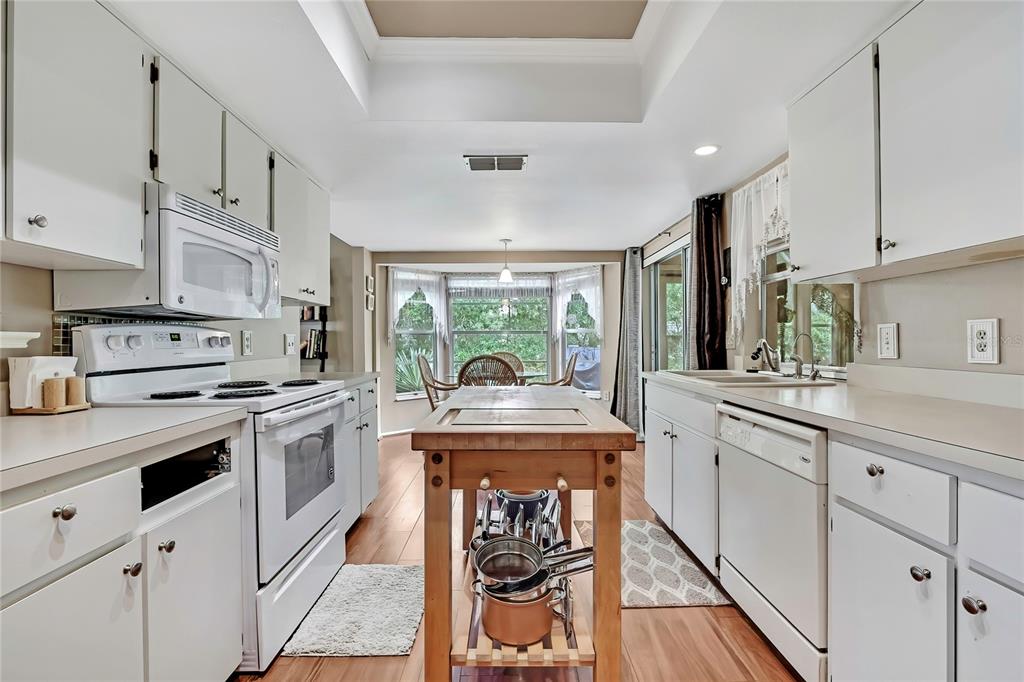 6517 Ocean Pines Lane Spring Hill, FL 34606 - Photo 8 of 72 a kitchen with white cabinets and white appliances
