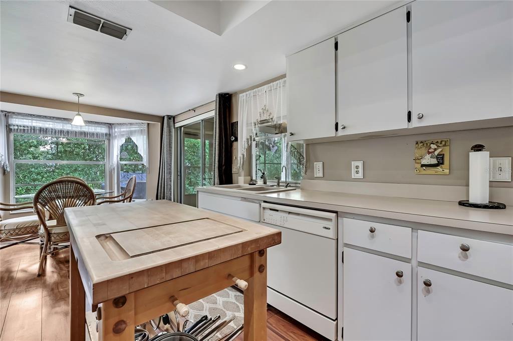 6517 Ocean Pines Lane Spring Hill, FL 34606 - Photo 9 of 72 a kitchen with granite countertop a stove a sink and a dining table with wooden floor
