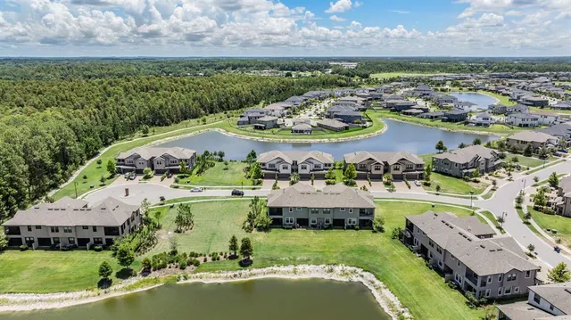 an aerial view of a house with a garden and lake view