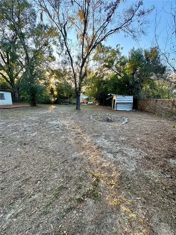 a view of a backyard with large trees