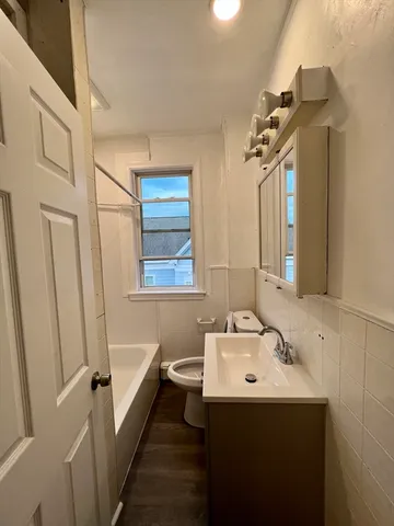 a bathroom with a sink and mirror with bathtub