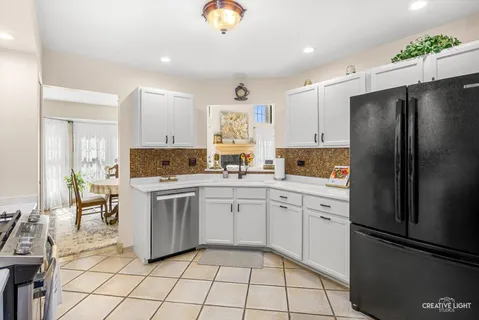 a kitchen with a refrigerator a sink and white cabinets