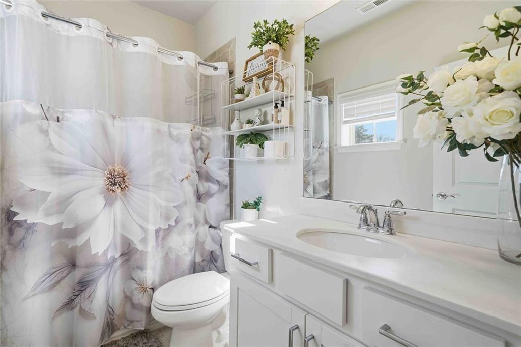 4631 Leader Lane Duluth, GA 30096 - Photo 26 of 55 a bathroom with a sink a toilet and a mirror