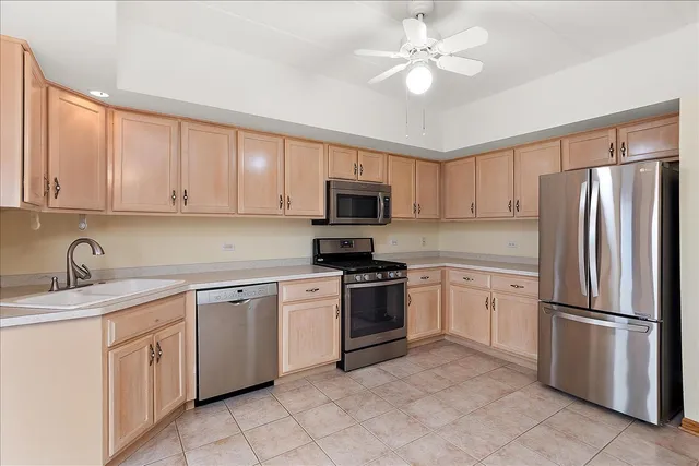 a kitchen with cabinets stainless steel appliances and a counter space