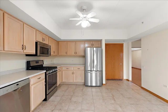 a kitchen with stainless steel appliances granite countertop a stove a refrigerator and a sink with cabinets