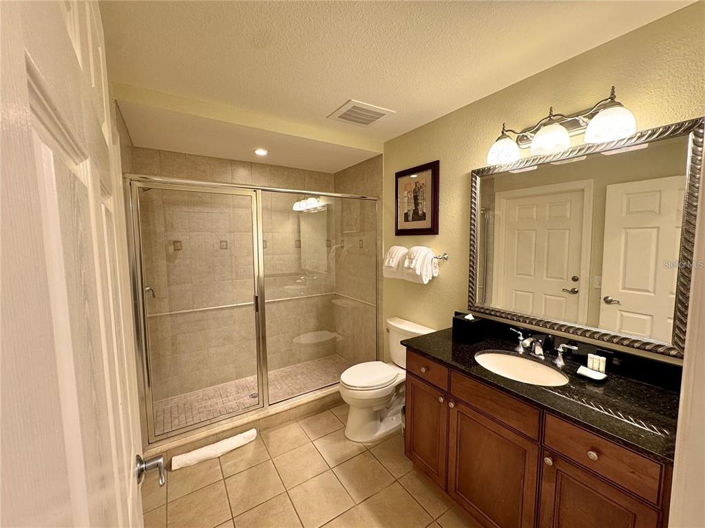 1350 Centre Ct Ridge Drive, Unit 101 Reunion, FL 34747 - Photo 6 of 9 a bathroom with a sink a toilet a mirror and shower