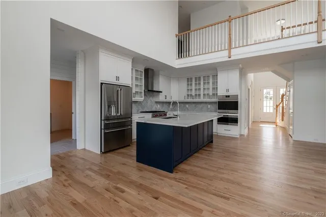 a large kitchen with stainless steel appliances granite countertop a sink and dishwasher a stove with wooden floor