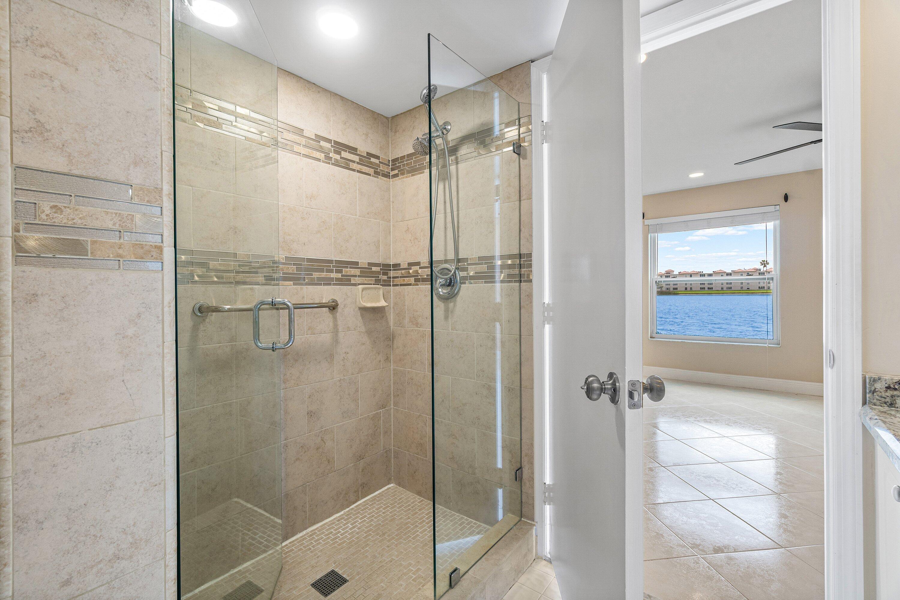 14096 Huntington Pointe Drive, Unit 106 Delray Beach, FL 33484 - Photo 40 of 47 a bathroom with a glass door shower