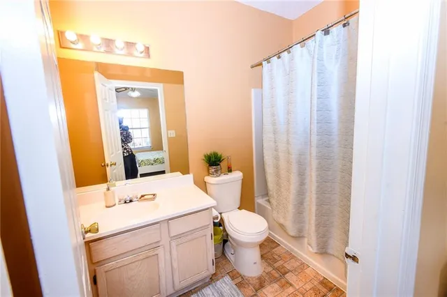 a bathroom with a sink a toilet and shower curtain