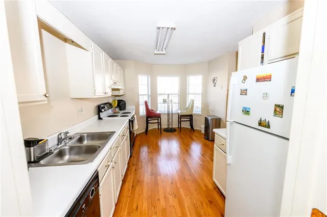 a kitchen with a sink a refrigerator and window